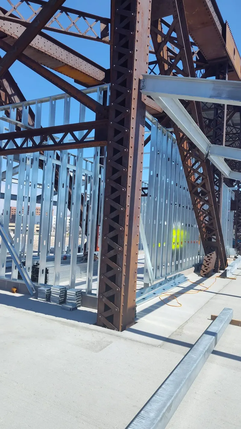 Metal stud framing connected to a commercial steel structure