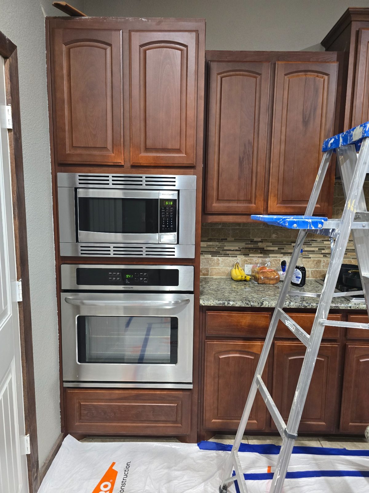 Kitchen cabinets during refinishing with protected area in DFW